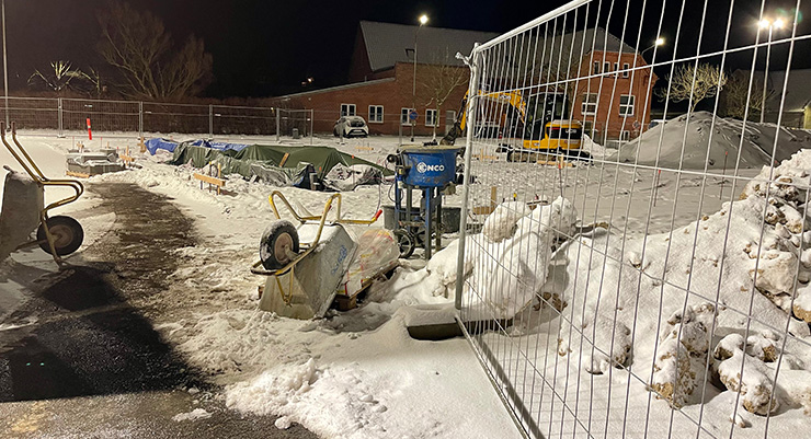 Byggeplads med sne og frostsikrede installationer
