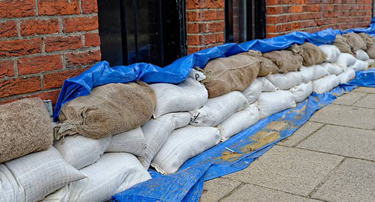 Sandsække foran kælderdør som midlertidig barriere mod vandindtrængning