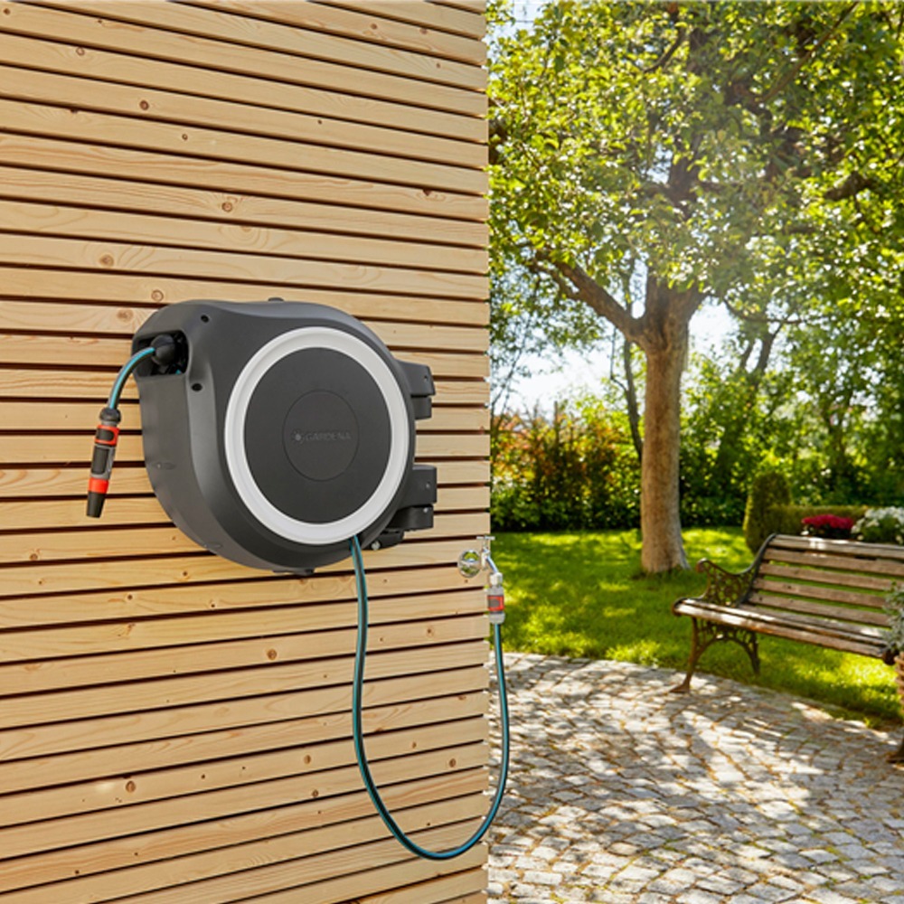 Sidevinkel af Gardena RollUp M/L 25m slangeoprulleren, der fremviser dens kompakte og fleksible design mod en havebaggrund.