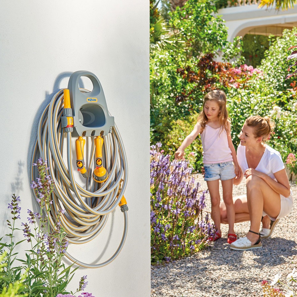 Hozelock slangeholder monteret på væg med haveslange i brug